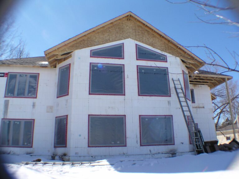 Two-storey ICF house with the roof framed, foam walls and windows in, winter