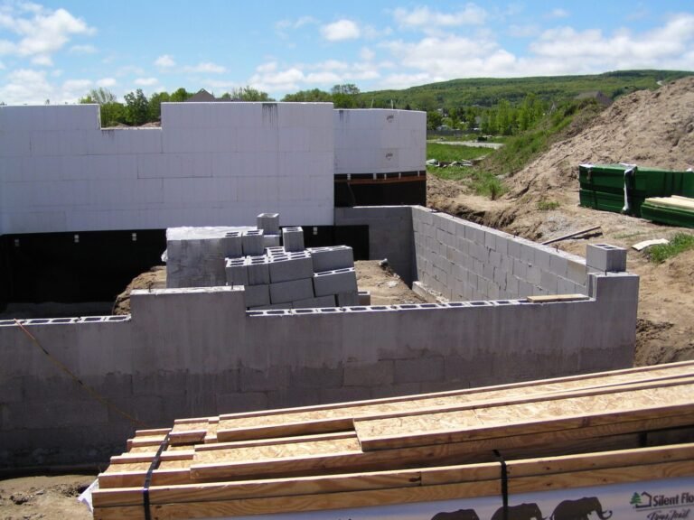 ICF forms stacked on a concrete block foundation, lumber in front